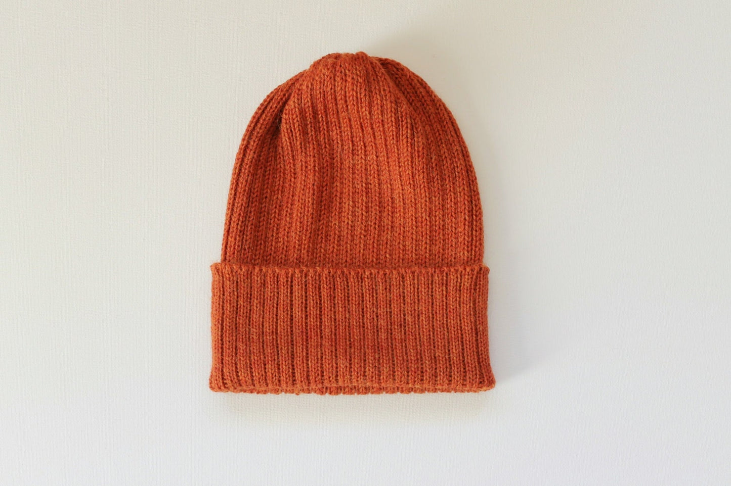 Rust/ burnt orange knitted alpaca beanie hat for babies, toddlers and children. Handcrafted in Scotland. Unisex design.